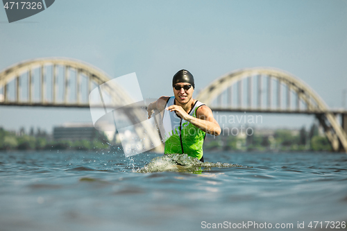 Image of Professional triathlete swimming in river\'s open water