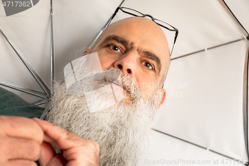 Image of bearded man with glasses and umbrella