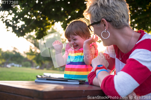 Image of mom and her little daughter using tablet computer