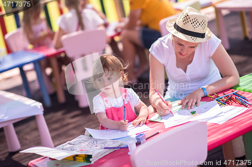 Image of mom and little daughter drawing a colorful pictures