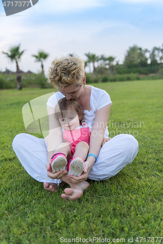 Image of mother and little daughter playing at backyard