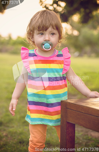 Image of little girl spending time at backyard