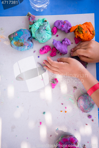 Image of kid hands Playing with Colorful Clay