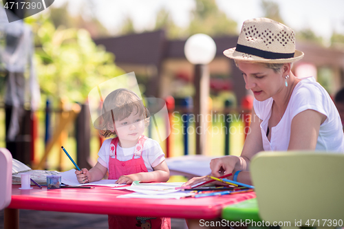 Image of mom and little daughter drawing a colorful pictures