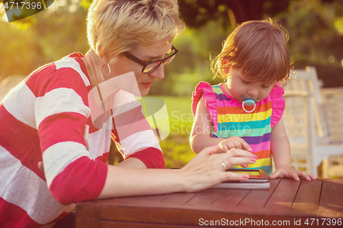 Image of mom and her little daughter using tablet computer