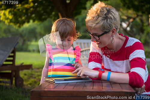 Image of mom and her little daughter using tablet computer