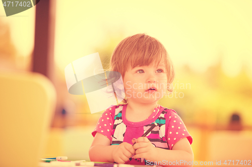 Image of little girl drawing a colorful pictures