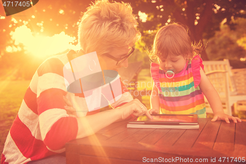 Image of mom and her little daughter using tablet computer