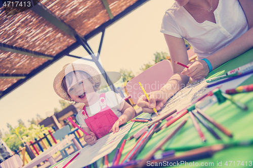 Image of mom and little daughter drawing a colorful pictures