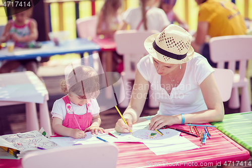 Image of mom and little daughter drawing a colorful pictures