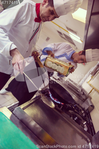 Image of chef preparing food, frying in wok pan