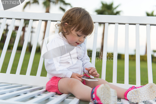 Image of little girl playing with mobile phone