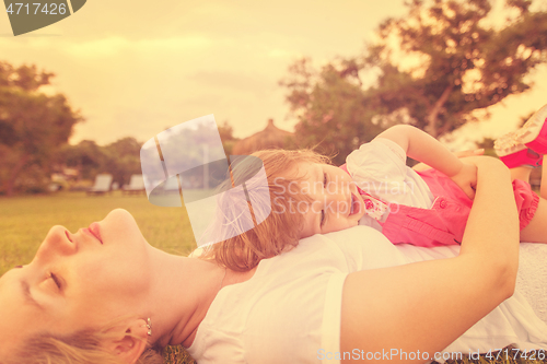 Image of mother and little daughter playing at backyard