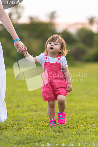 Image of mother and little daughter playing at backyard