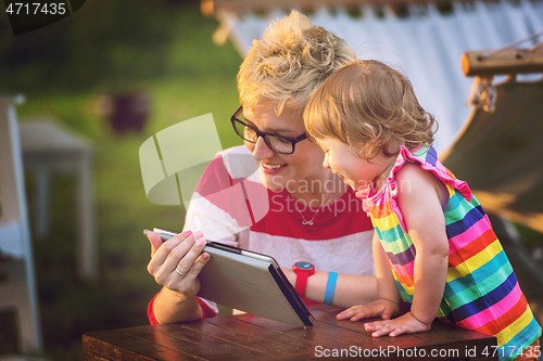 Image of mom and her little daughter using tablet computer