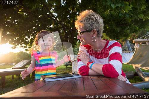 Image of mom and her little daughter using tablet computer