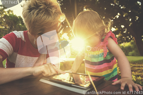 Image of mom and her little daughter using tablet computer