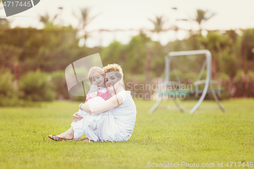 Image of mother and little daughter playing at backyard