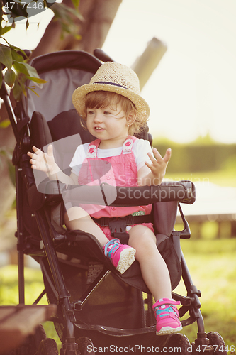 Image of baby girl sitting in the baby stroller