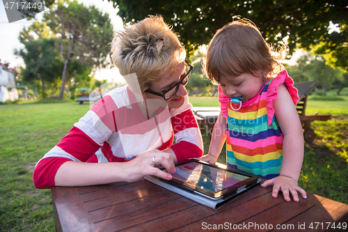 Image of mom and her little daughter using tablet computer