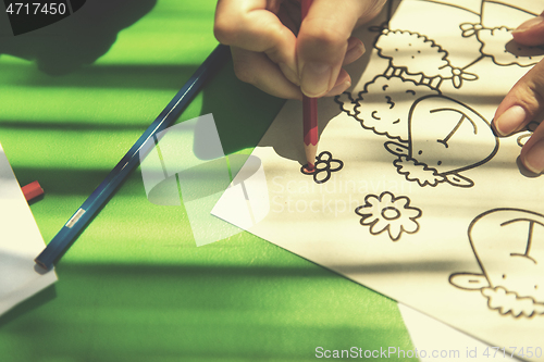 Image of closeup of hands drawing a colorful pictures