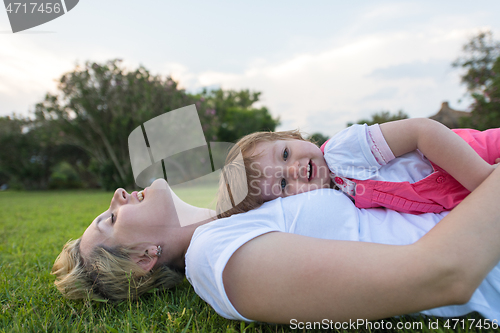 Image of mother and little daughter playing at backyard