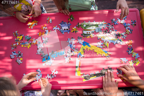 Image of top view of kids hands playing with puzzles