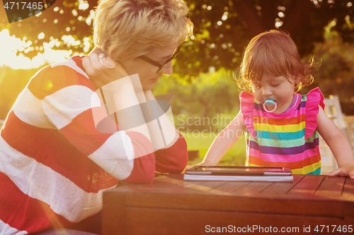 Image of mom and her little daughter using tablet computer