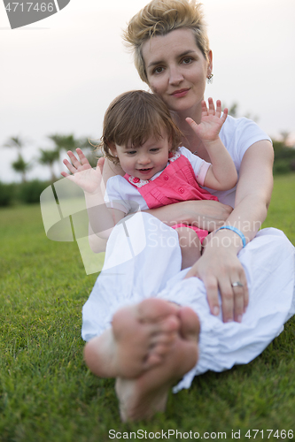 Image of mother and little daughter playing at backyard