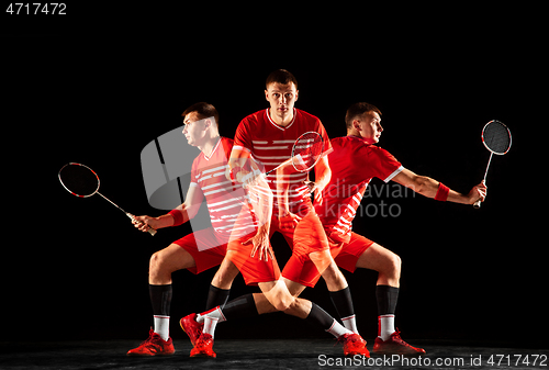 Image of Young man playing badminton isolated on black studio background