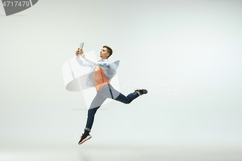 Image of Man working at office and jumping isolated on studio background