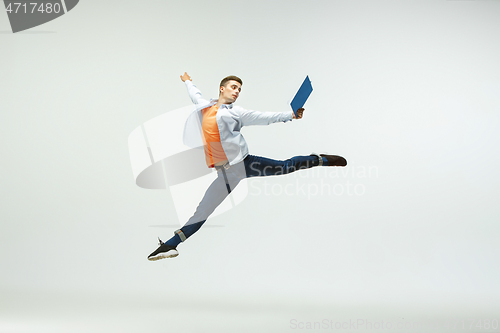 Image of Man working at office and jumping isolated on studio background