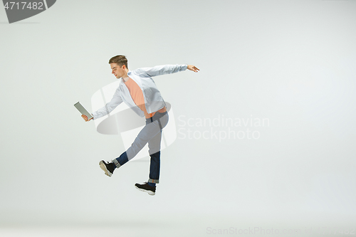 Image of Man working at office and jumping isolated on studio background