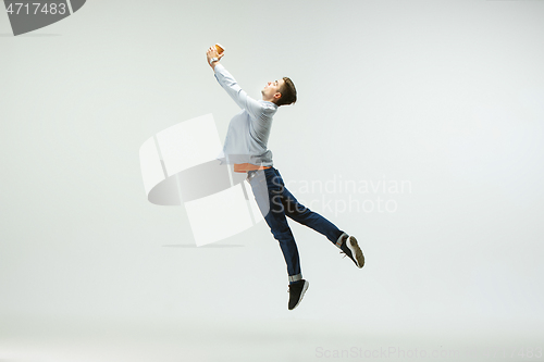 Image of Man working at office and jumping isolated on studio background