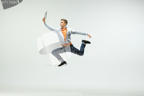 Image of Man working at office and jumping isolated on studio background