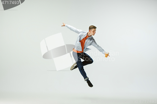 Image of Man working at office and jumping isolated on studio background