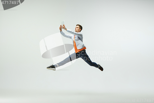 Image of Man working at office and jumping isolated on studio background