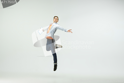 Image of Man working at office and jumping isolated on studio background