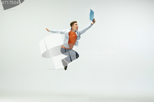 Image of Man working at office and jumping isolated on studio background