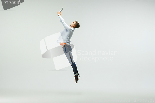 Image of Man working at office and jumping isolated on studio background