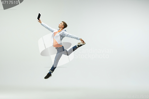 Image of Man working at office and jumping isolated on studio background