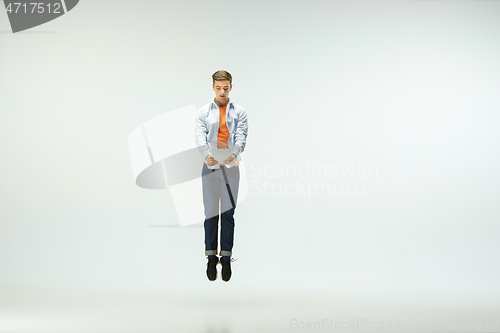 Image of Man working at office and jumping isolated on studio background