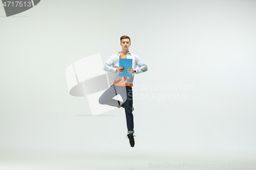 Image of Man working at office and jumping isolated on studio background