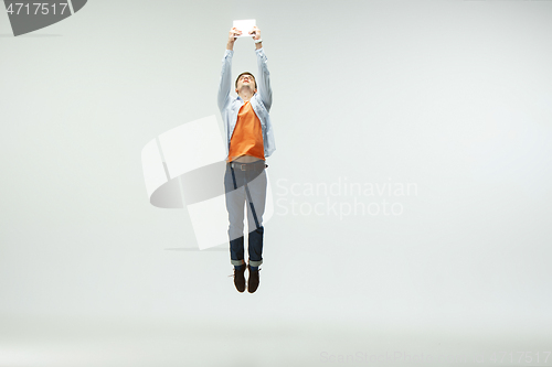 Image of Man working at office and jumping isolated on studio background