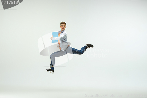 Image of Man working at office and jumping isolated on studio background