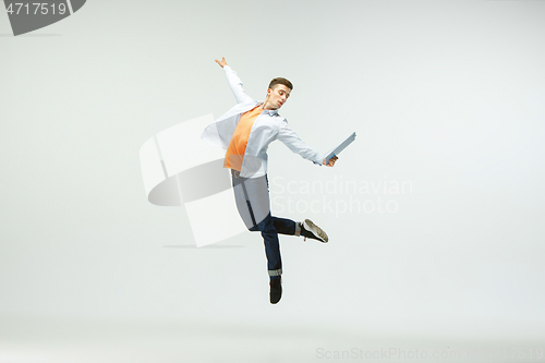 Image of Man working at office and jumping isolated on studio background