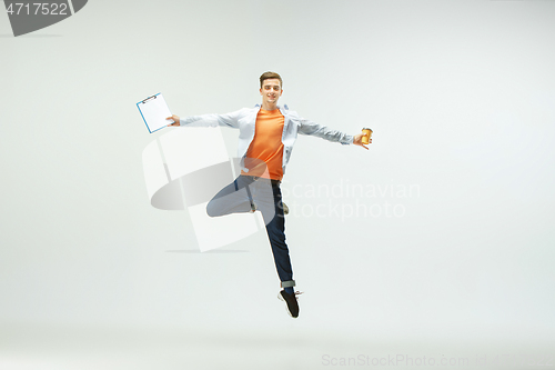 Image of Man working at office and jumping isolated on studio background