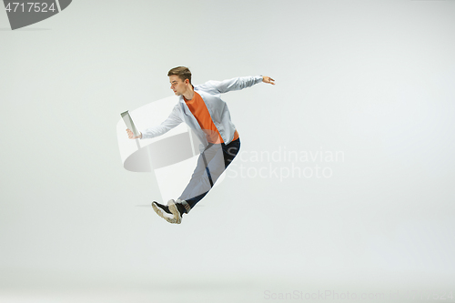 Image of Man working at office and jumping isolated on studio background