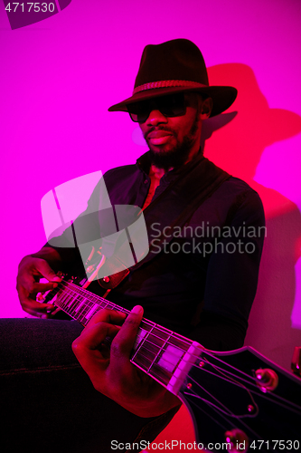 Image of Young african-american jazz musician playing the guitar