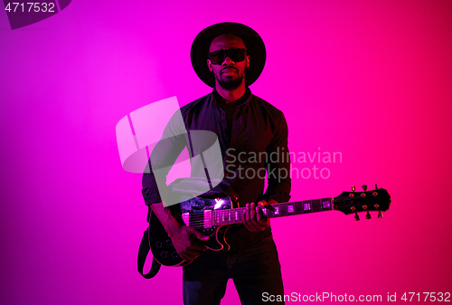 Image of Young african-american jazz musician playing the guitar